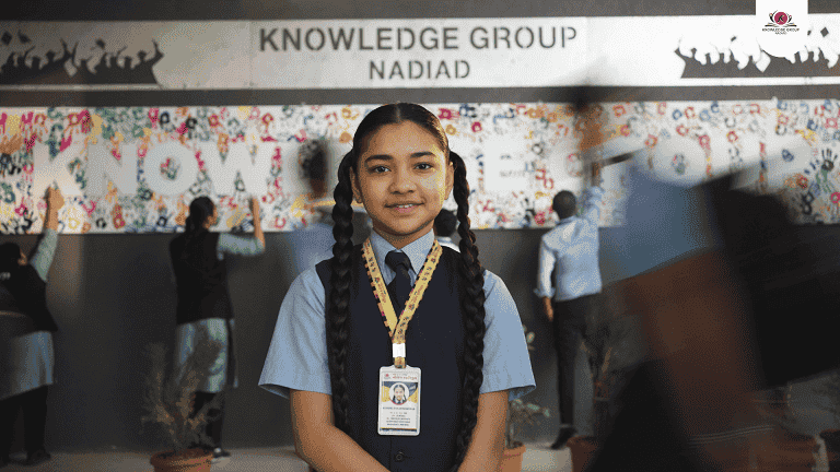A student standing proudly in front of a colorful mural, captured by top education video makers in Ahmedabad