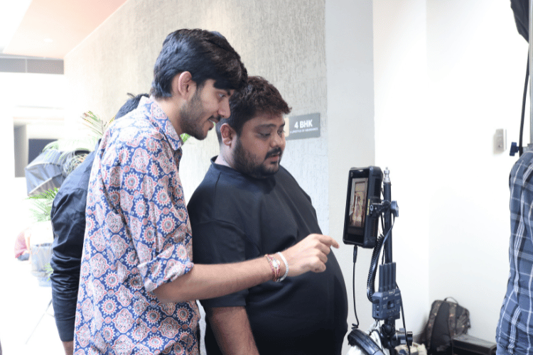 Crew adjusting camera settings during a corporate video shoot in Vadodara